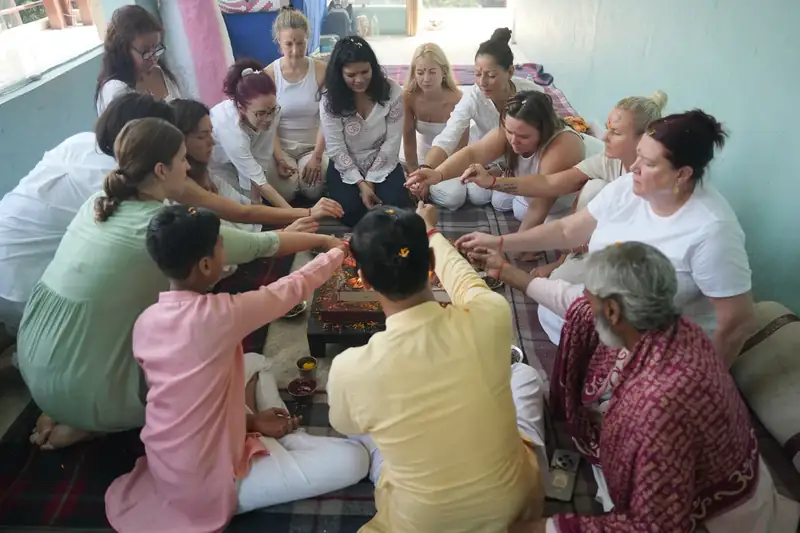 Students seated in a circle around the ceremonial fire during a yagna at Sri Yoga Ashram